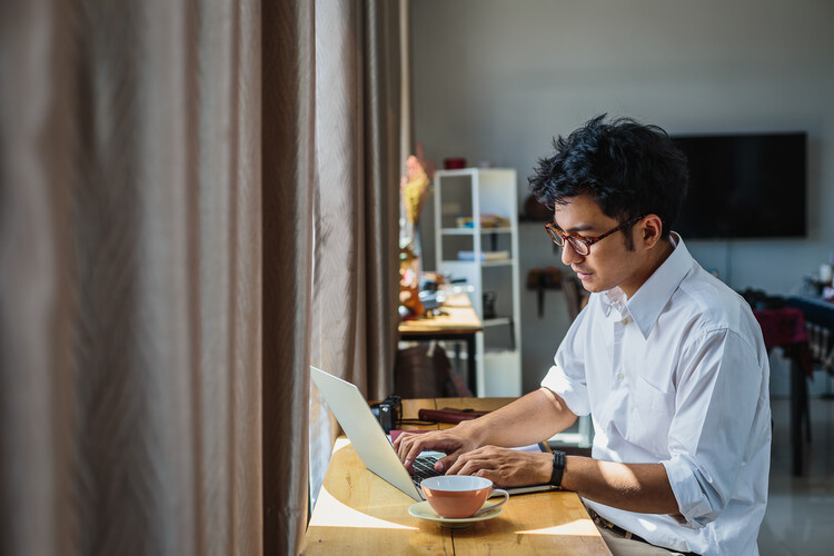 young man filling out application on laptop