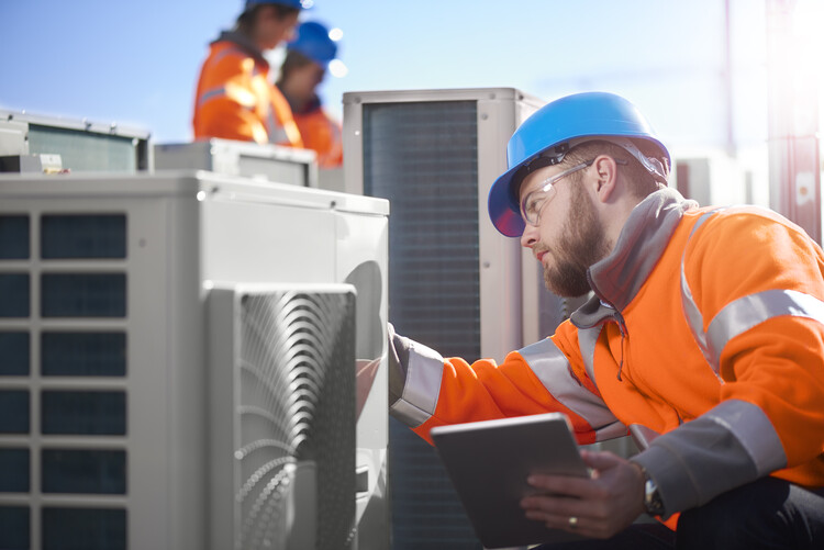 airconditioning man fixing aircon unit on rooftop